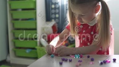 一个小女孩用珠子做手镯